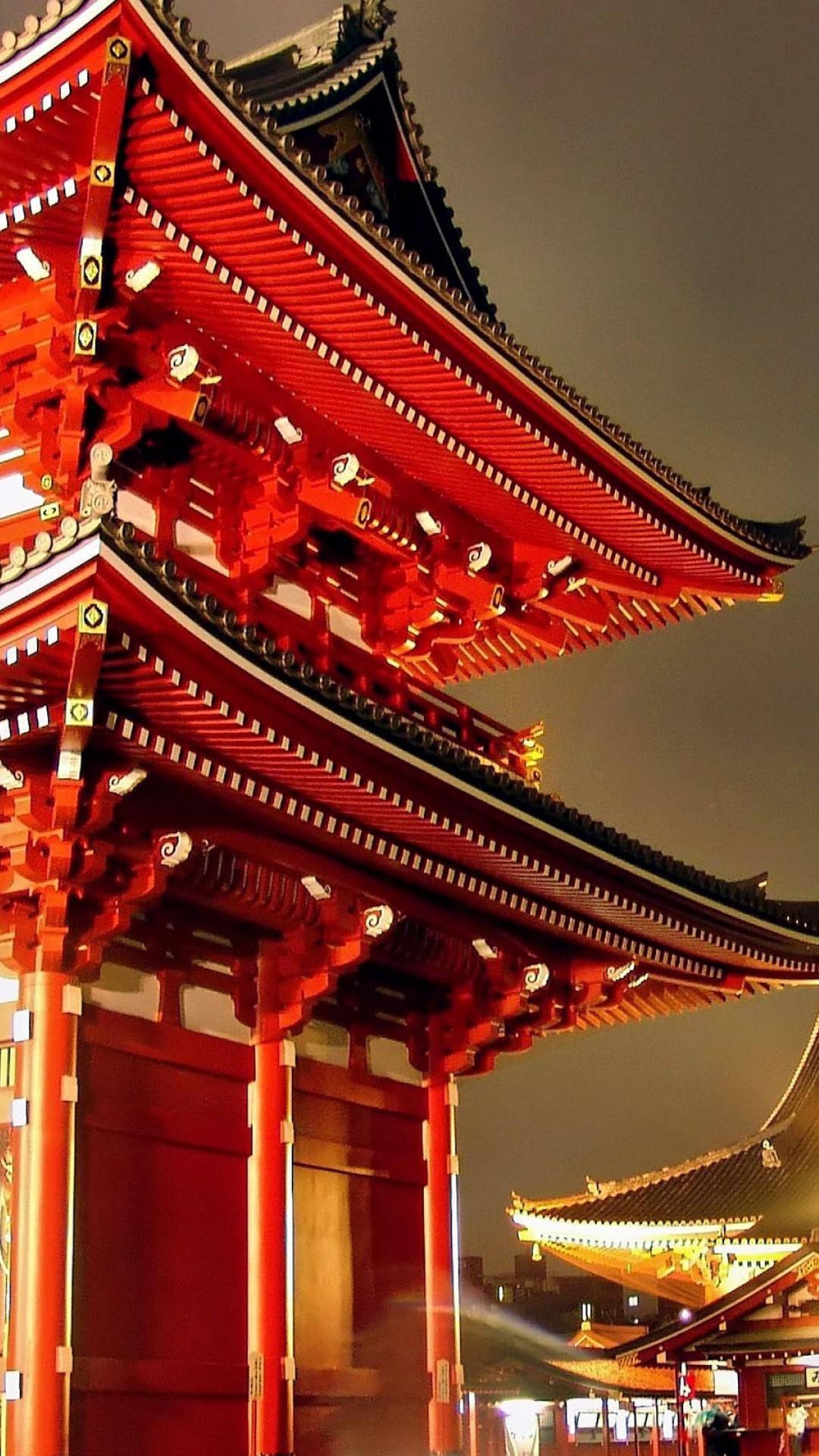 Leute, Die Nachts Auf Der Straße in Der Nähe Des Braunen Und Roten Tempels Gehen. Wallpaper in 1080x1920 Resolution