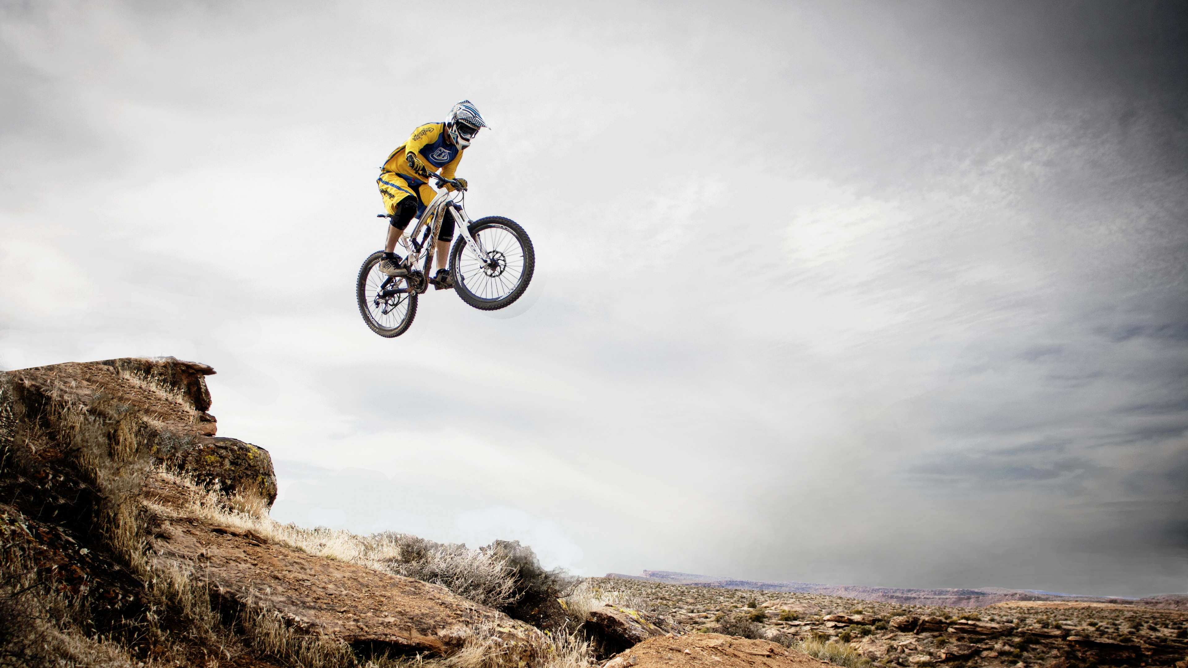 Hombre de Chaqueta Verde Montando en Bicicleta en el Campo de Hierba Verde Bajo el Cielo Nublado Blanco Durante. Wallpaper in 3840x2160 Resolution