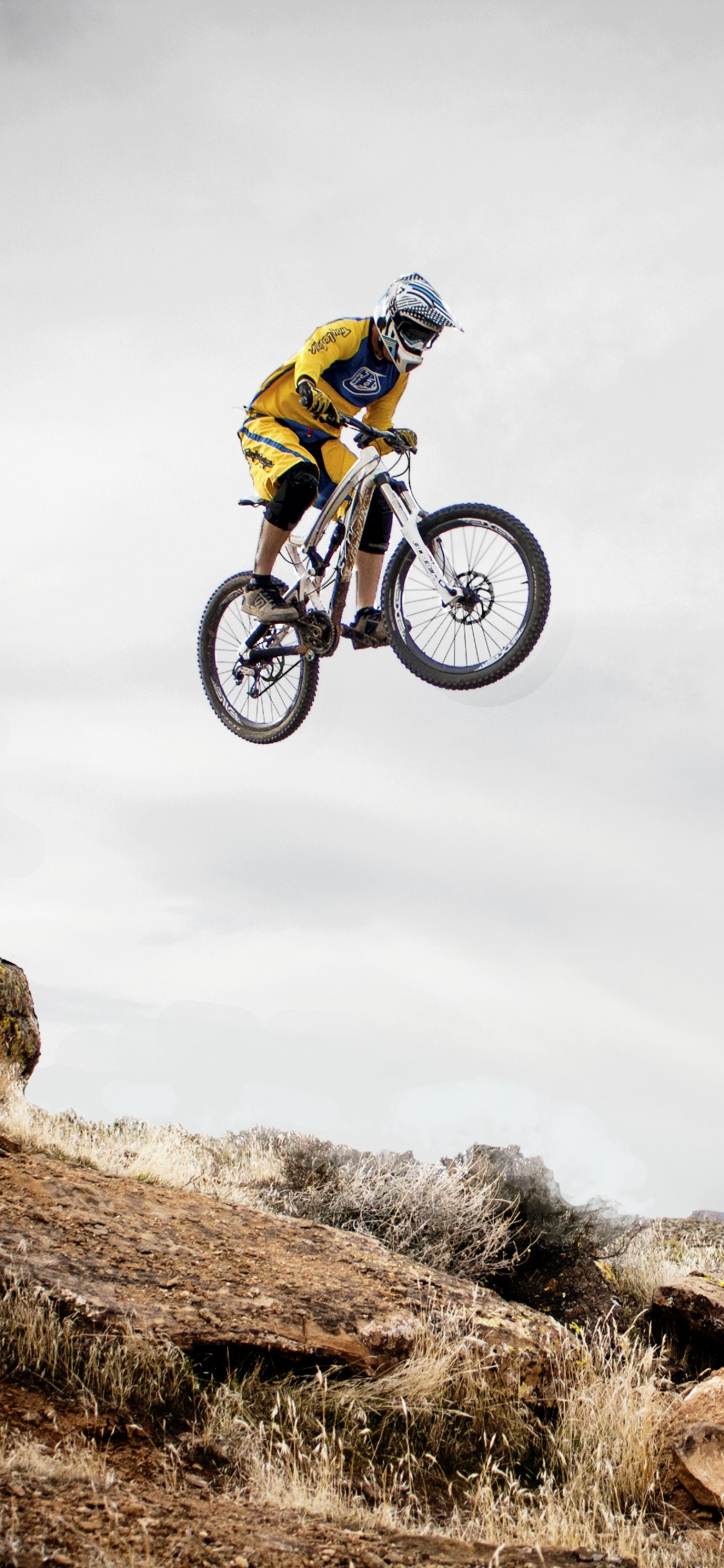 Man in Green Jacket Riding on Bicycle on Green Grass Field Under White Cloudy Sky During. Wallpaper in 1125x2436 Resolution