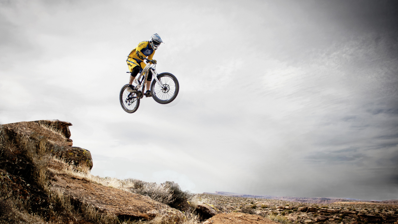 Man in Green Jacket Riding on Bicycle on Green Grass Field Under White Cloudy Sky During. Wallpaper in 1366x768 Resolution