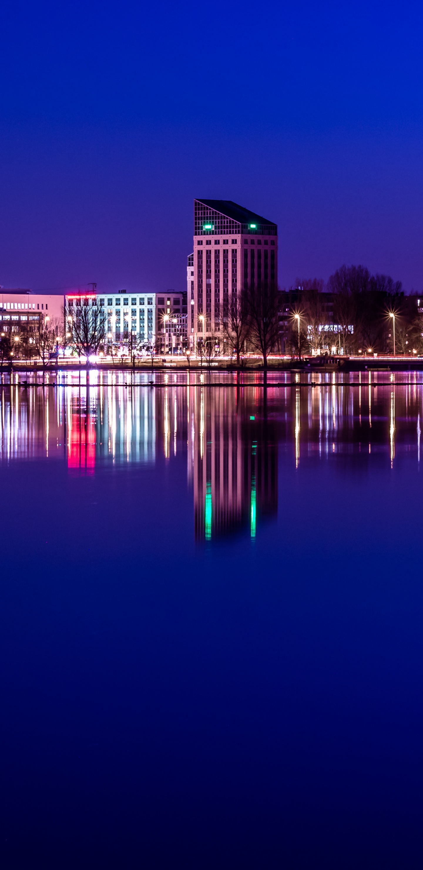 Braunes Betongebäude in Der Nähe Von Gewässern Während Der Nacht. Wallpaper in 1440x2960 Resolution