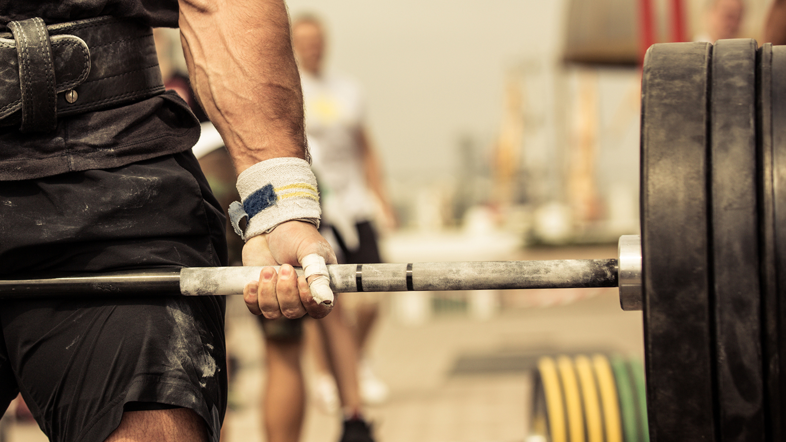 Mann in Schwarzen Shorts Mit Langhantel. Wallpaper in 2560x1440 Resolution