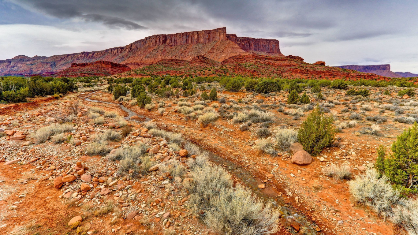Green Grass on Brown Rocky Mountain Under Cloudy Sky During Daytime. Wallpaper in 1366x768 Resolution