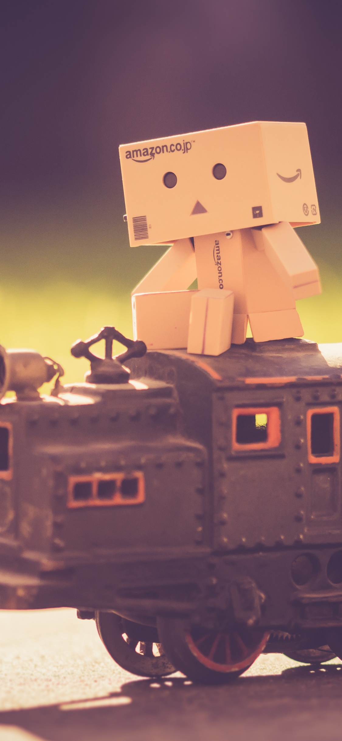 Robot de Cartón Marrón en Tren Negro. Wallpaper in 1125x2436 Resolution