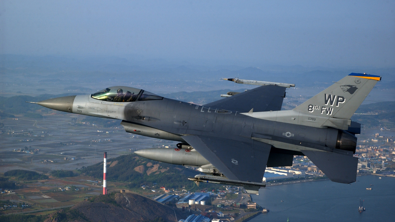 Avion de Chasse Gris Survolant la Ville Pendant la Journée. Wallpaper in 1366x768 Resolution