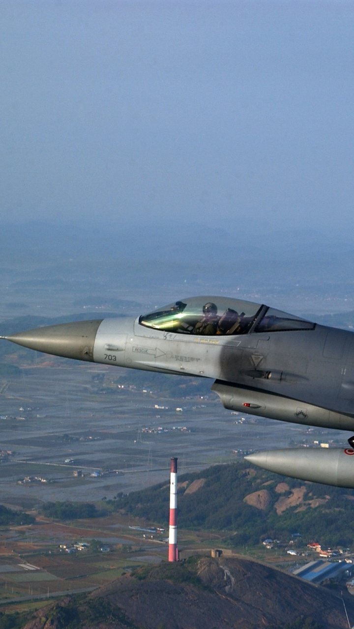 Avion de Chasse Gris Survolant la Ville Pendant la Journée. Wallpaper in 720x1280 Resolution