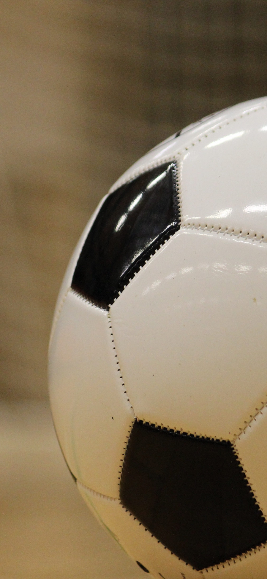 Ballon de Football Blanc et Noir Sur Plancher en Bois Marron. Wallpaper in 1125x2436 Resolution