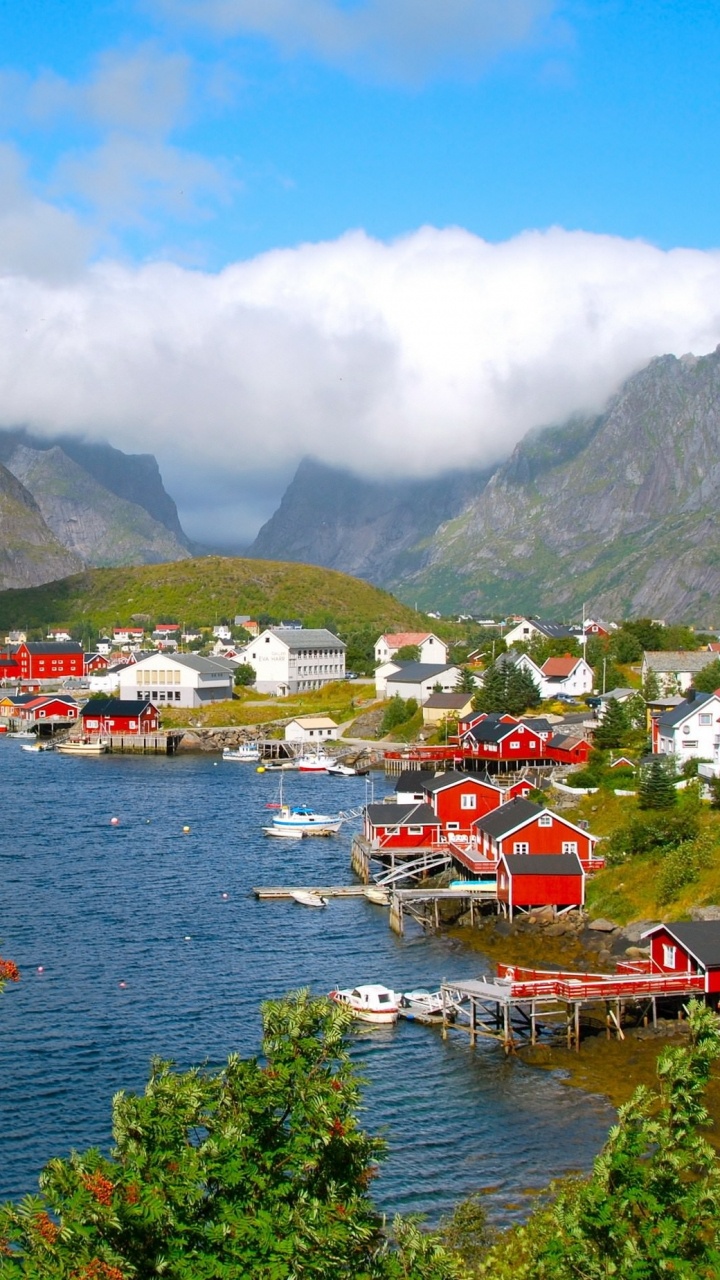 Rotes Und Weißes Boot Auf Dem Wasser in Der Nähe Des Grünen Berges Unter Blauem Himmel Tagsüber. Wallpaper in 720x1280 Resolution