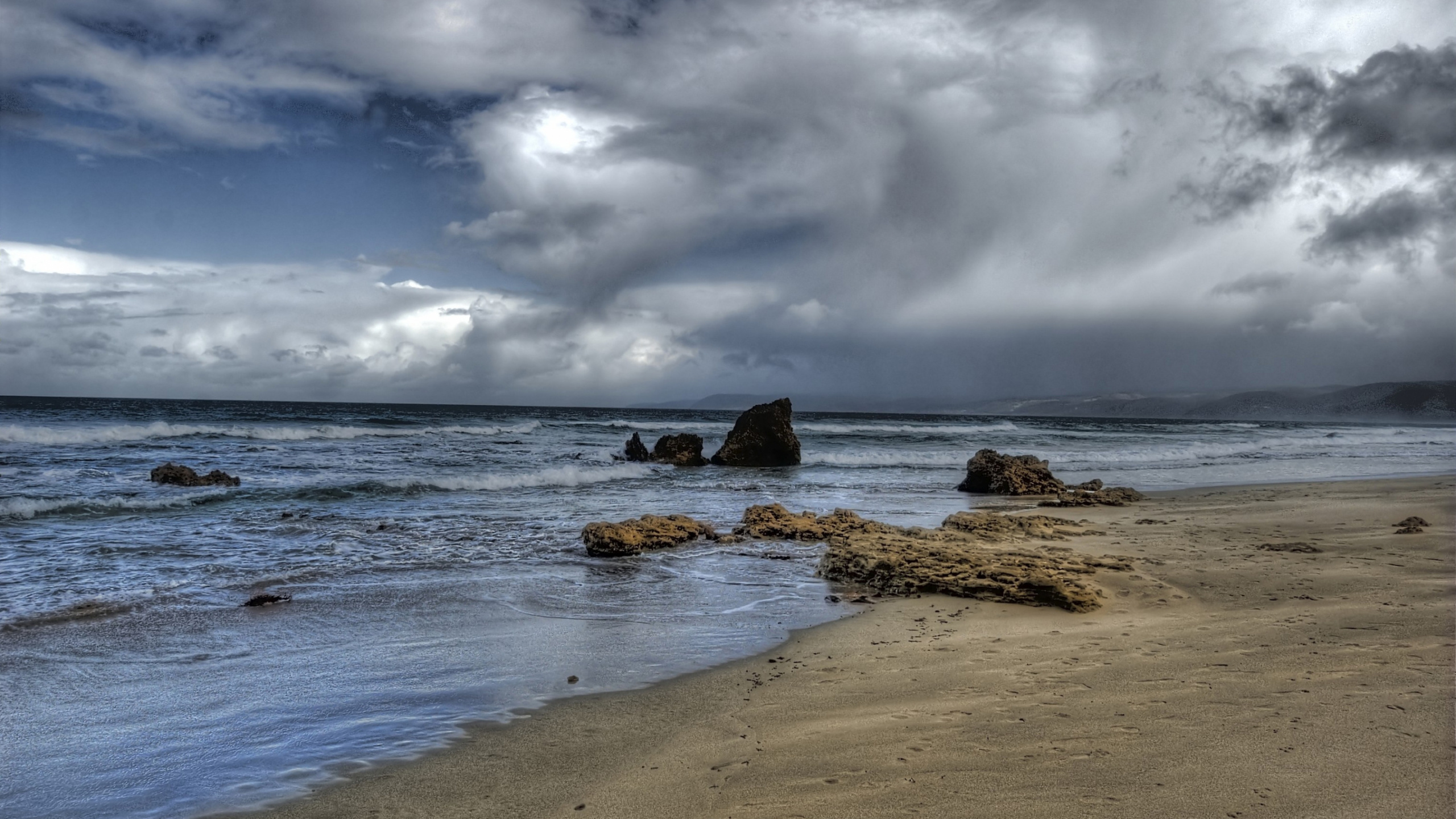 Formation de Roche Brune Sur le Bord de Mer Sous Les Nuages Blancs et le Ciel Bleu Pendant la Journée. Wallpaper in 2560x1440 Resolution