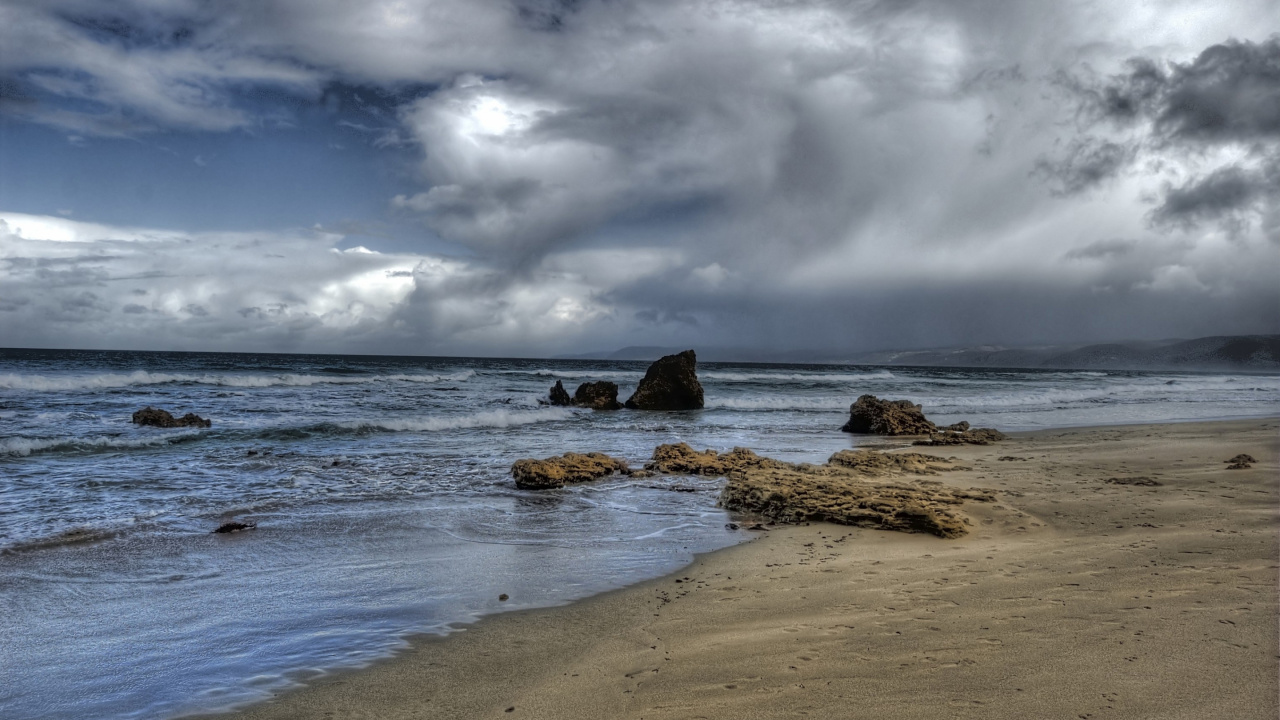 Formación de Roca Marrón en la Orilla Del Mar Bajo Las Nubes Blancas y el Cielo Azul Durante el Día. Wallpaper in 1280x720 Resolution