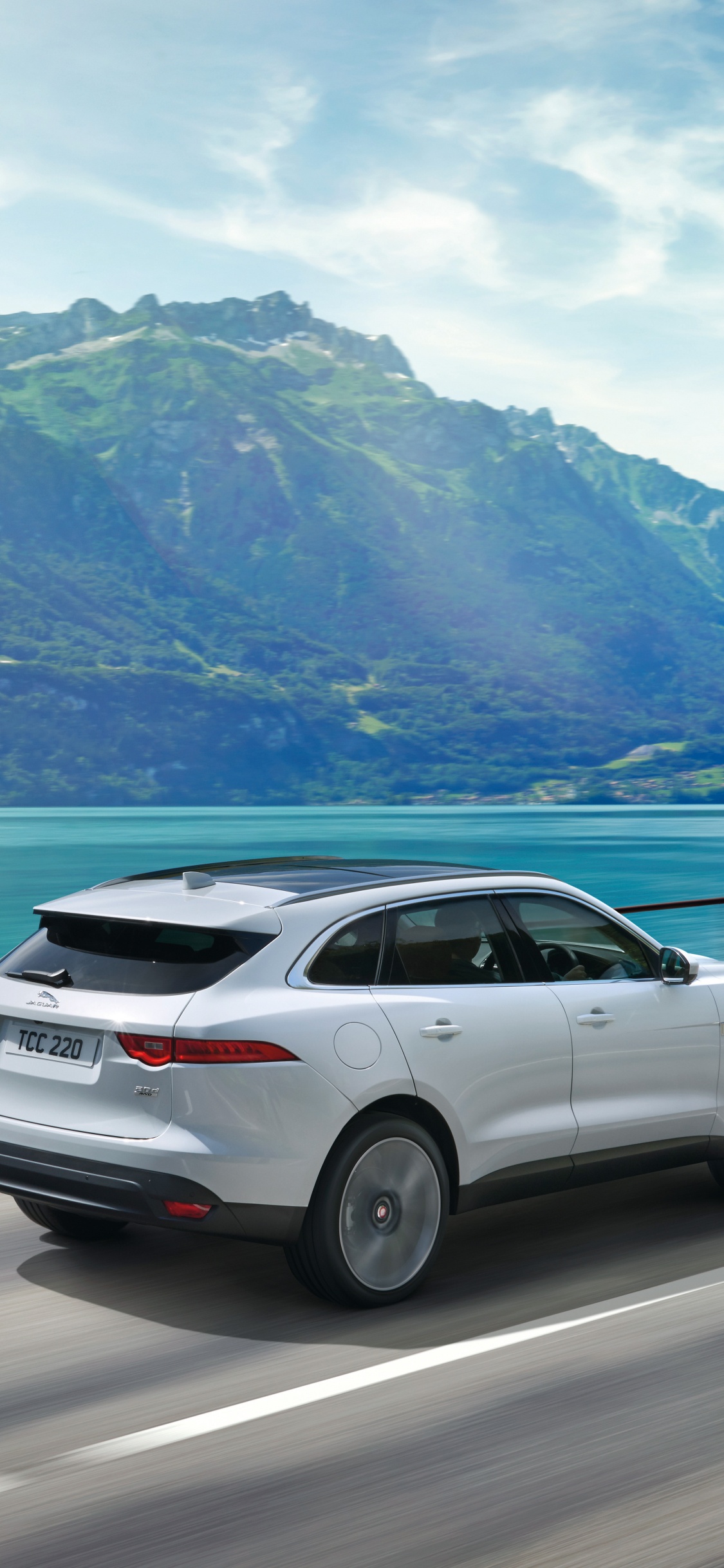 Suv Blanco en la Carretera Cerca Del Cuerpo de Agua Durante el Día. Wallpaper in 1125x2436 Resolution