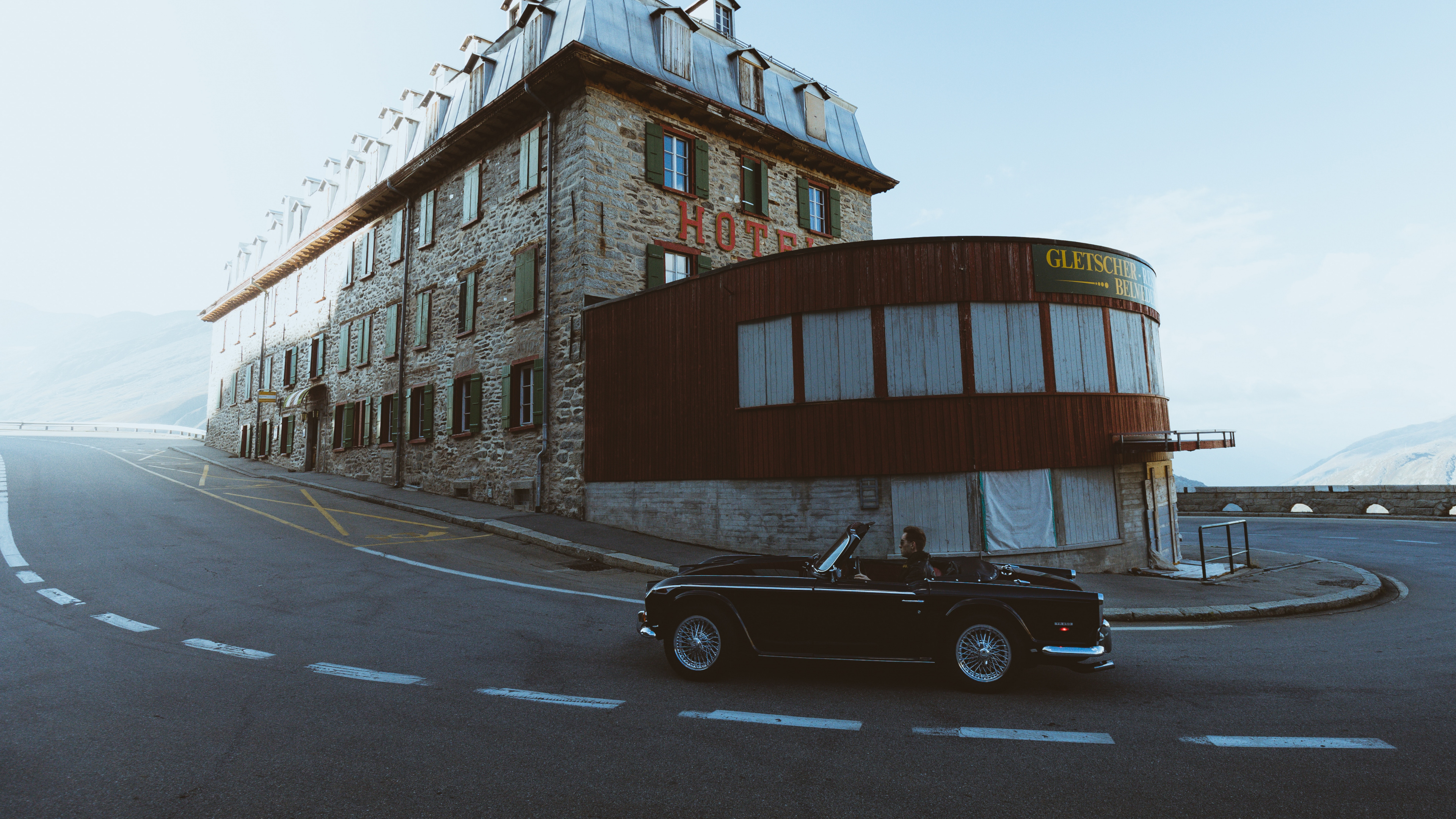 Black Coupe Parked Beside Brown Concrete Building During Daytime. Wallpaper in 3840x2160 Resolution