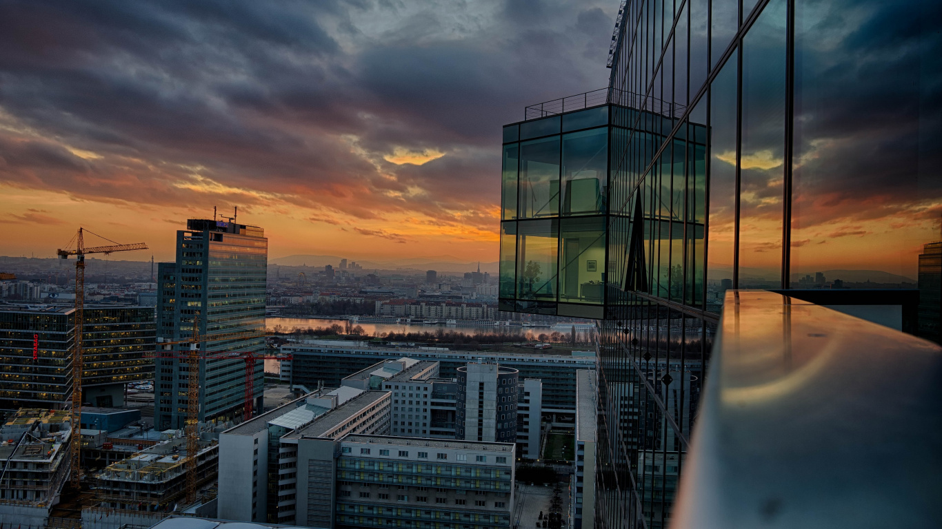 Skyline Der Stadt Unter Bewölktem Himmel Bei Sonnenuntergang. Wallpaper in 1366x768 Resolution