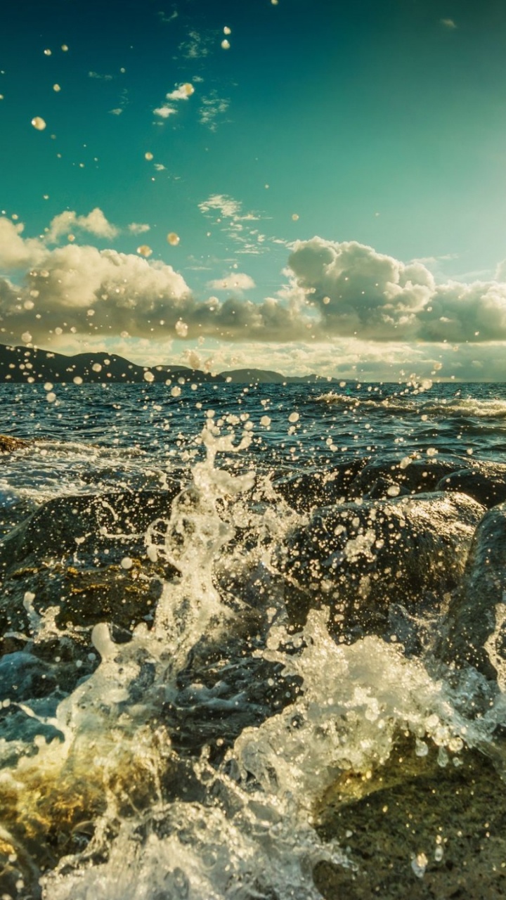 Les Vagues de L'océan S'écrasent Sur Les Rochers Sous le Ciel Bleu Pendant la Journée. Wallpaper in 720x1280 Resolution