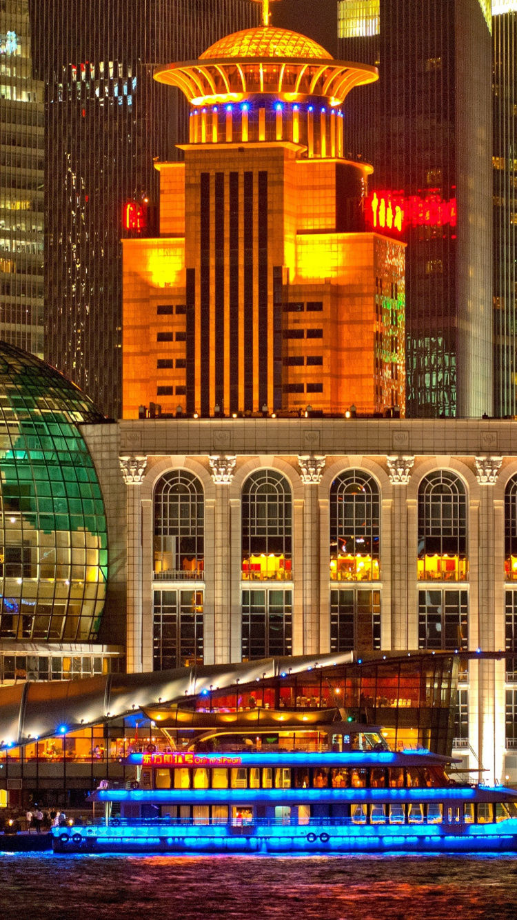 Brown Concrete Building Near Body of Water During Night Time. Wallpaper in 750x1334 Resolution