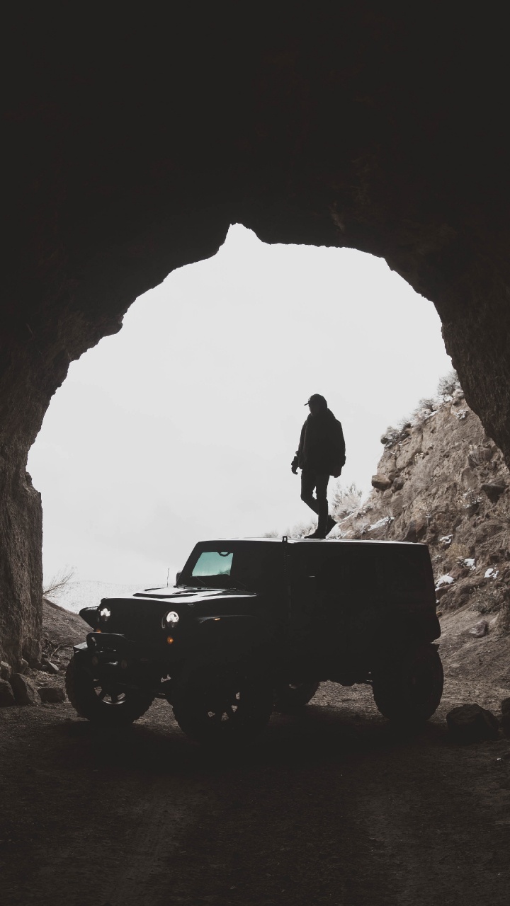Homme en Veste Noire Debout Sur Une Jeep Wrangler Noire à L'intérieur de la Grotte Pendant la Journée. Wallpaper in 720x1280 Resolution