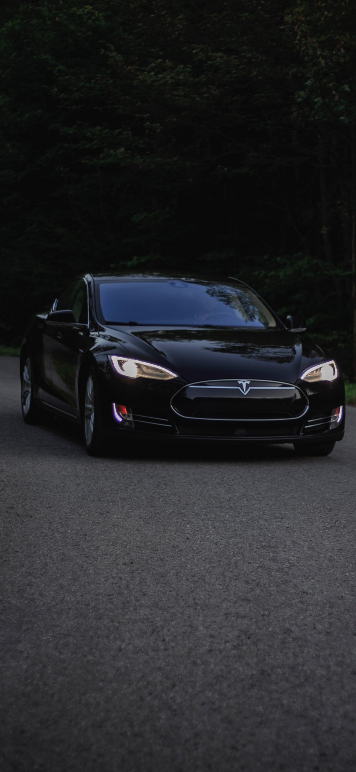 Schwarzes Auto Auf Grauer Asphaltstraße. Wallpaper in 1242x2688 Resolution