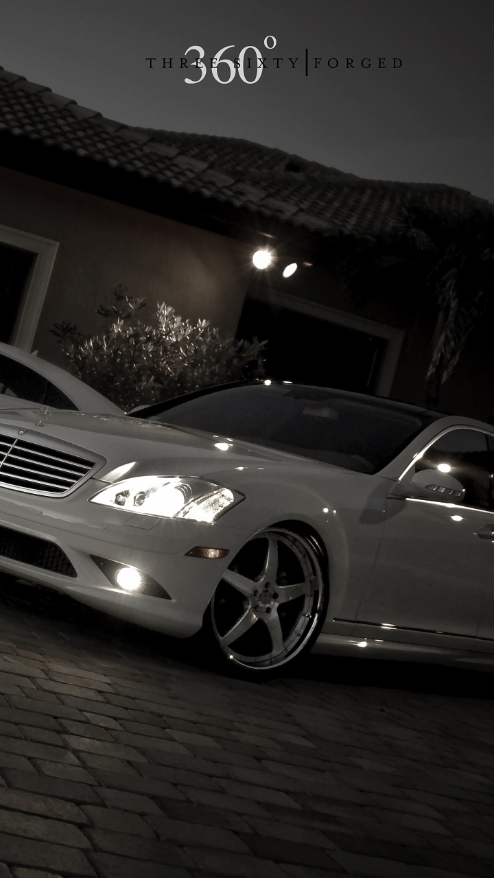 White Mercedes Benz Coupe Parked Near Brown Brick Wall. Wallpaper in 720x1280 Resolution