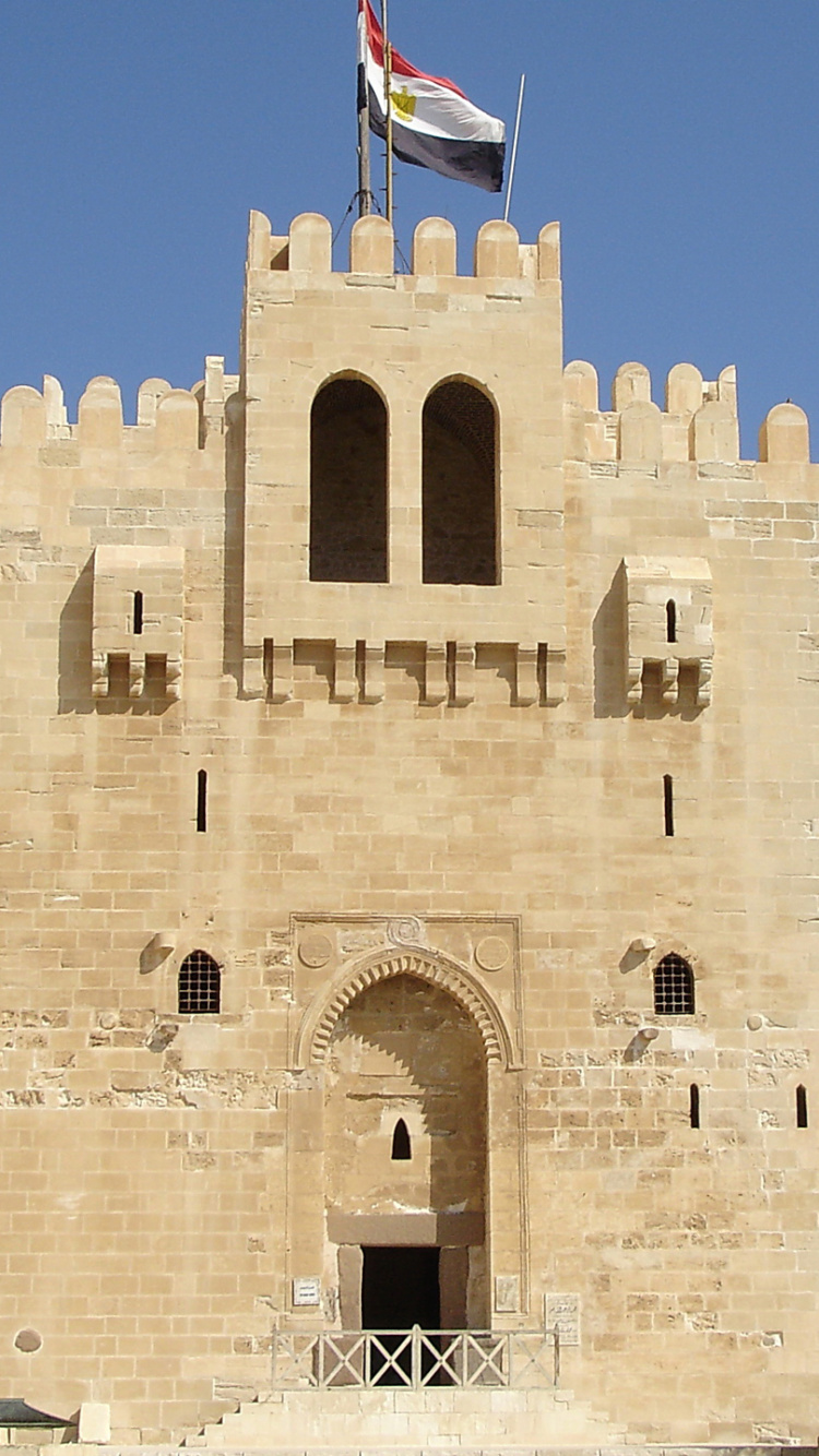 Braunes Betongebäude Mit Flaggen Tagsüber. Wallpaper in 750x1334 Resolution