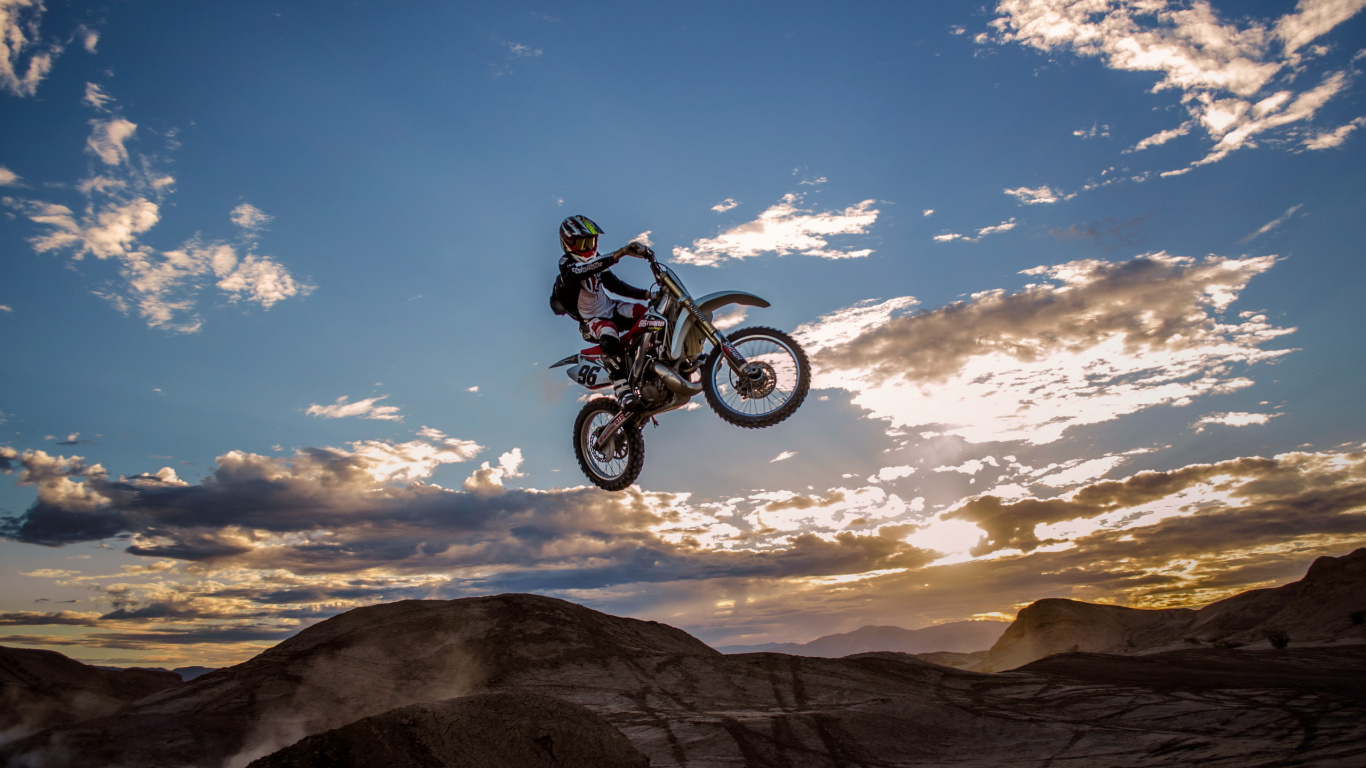Man Riding Motocross Dirt Bike Sur Brown Mountain Sous Ciel Bleu Pendant la Journée. Wallpaper in 1366x768 Resolution