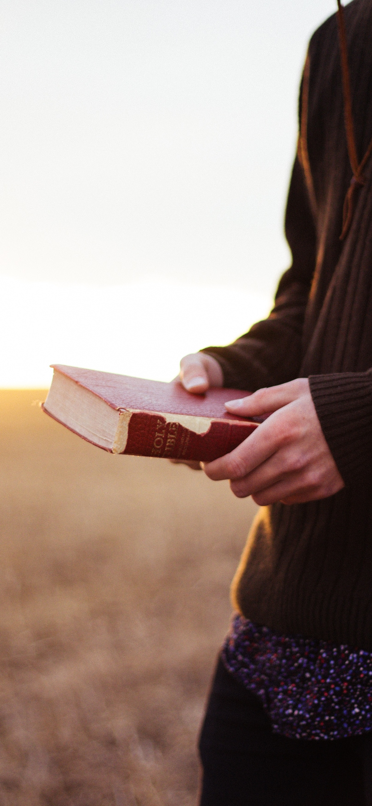 Person in Black Blazer Holding Book. Wallpaper in 1242x2688 Resolution