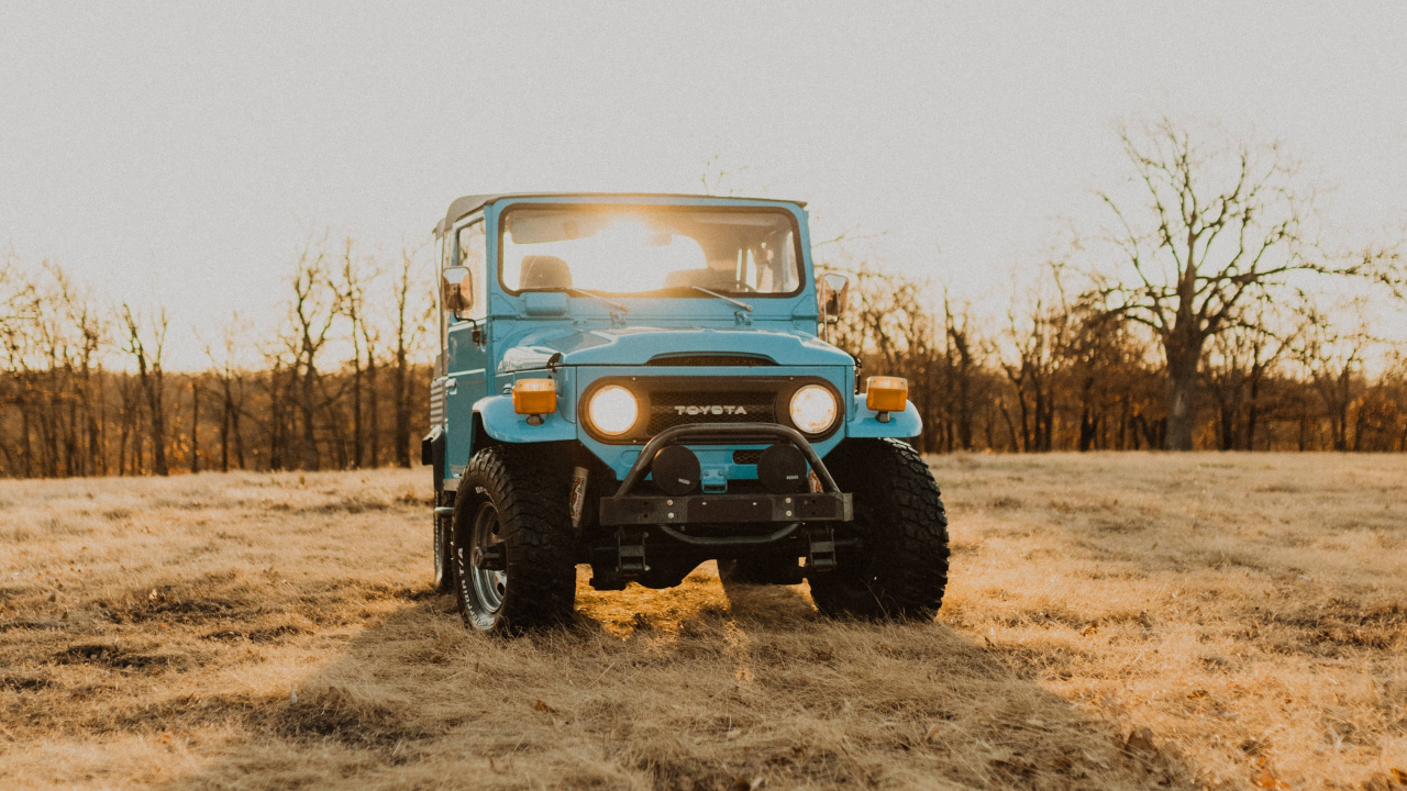 Jeep Wrangler Bleu et Blanc Sur Champ Brun Pendant la Journée. Wallpaper in 1280x720 Resolution