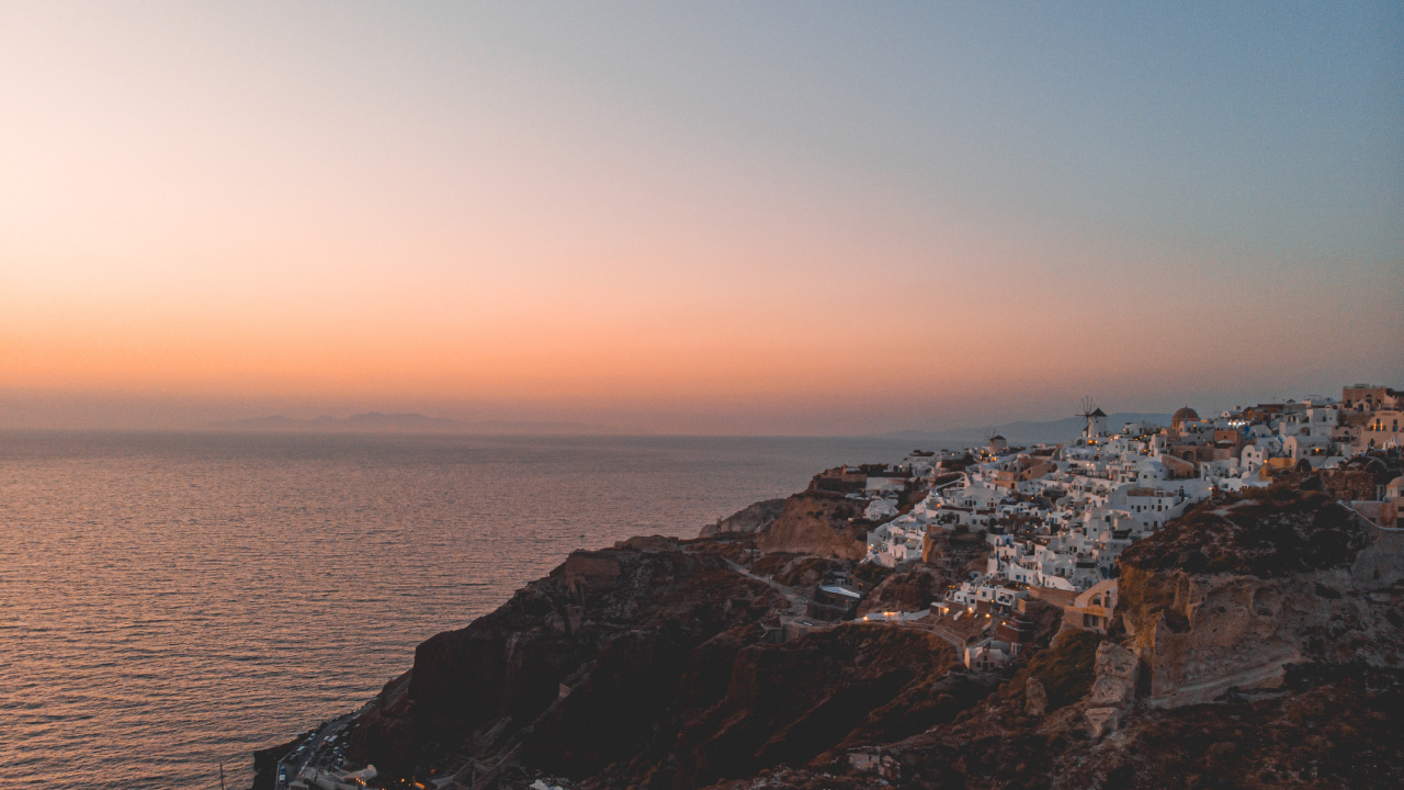 Brown Rocky Mountain Beside Sea During Sunset. Wallpaper in 1280x720 Resolution