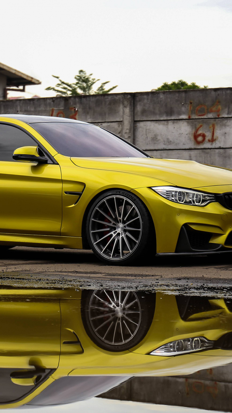 Mercedes Benz Coupe Amarillo Estacionado Junto a un Muro de Hormigón Marrón. Wallpaper in 750x1334 Resolution