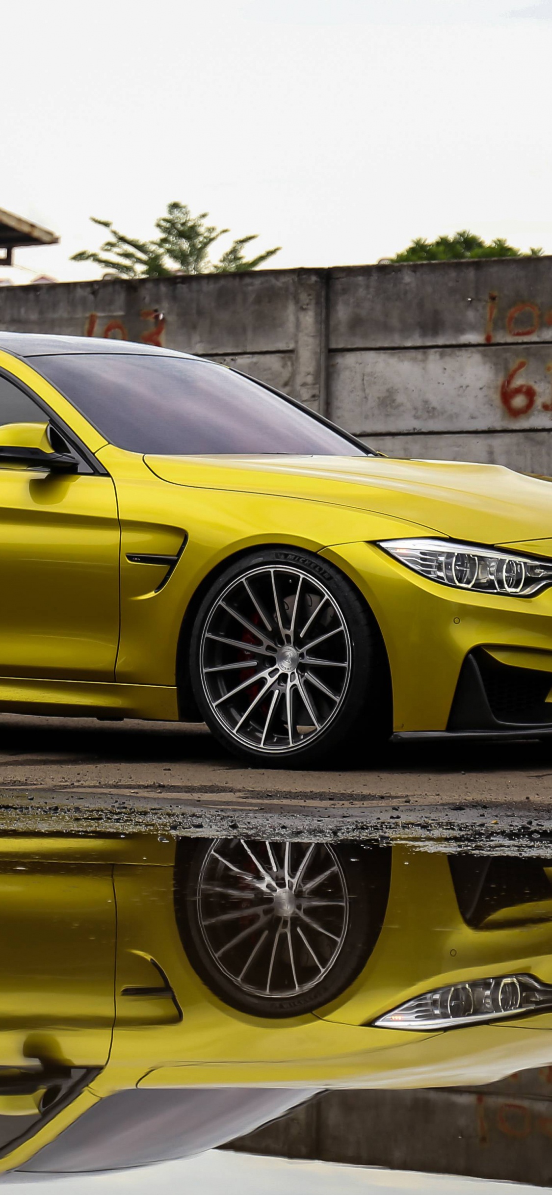 Mercedes Benz Coupé Jaune Garé à Côté D'un Mur de Béton Marron. Wallpaper in 1125x2436 Resolution