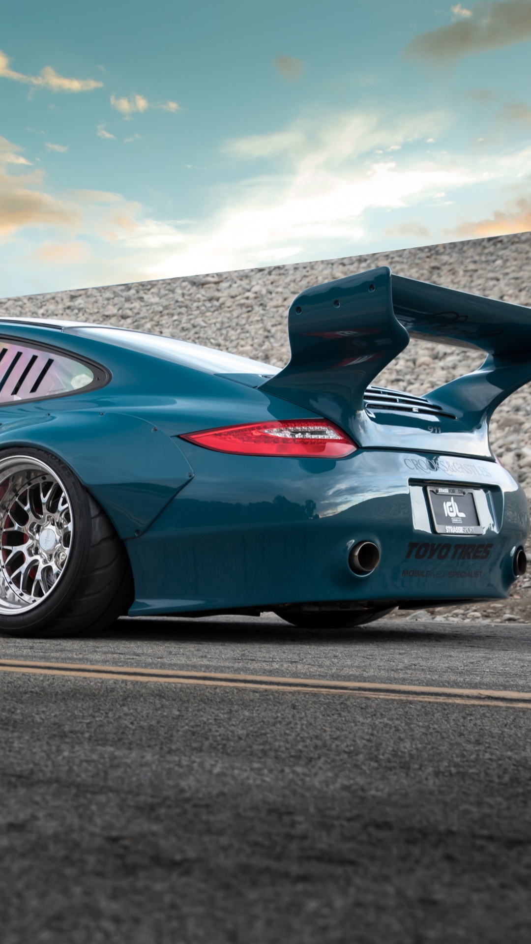 Blue Porsche 911 on Road Under Blue Sky. Wallpaper in 1080x1920 Resolution