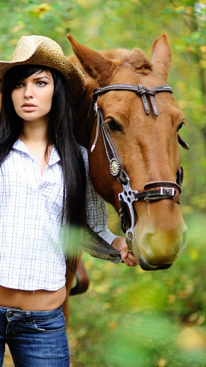 Woman in White and Black Striped Shirt and Blue Denim Jeans Standing Beside Brown Horse During. Wallpaper in 720x1280 Resolution