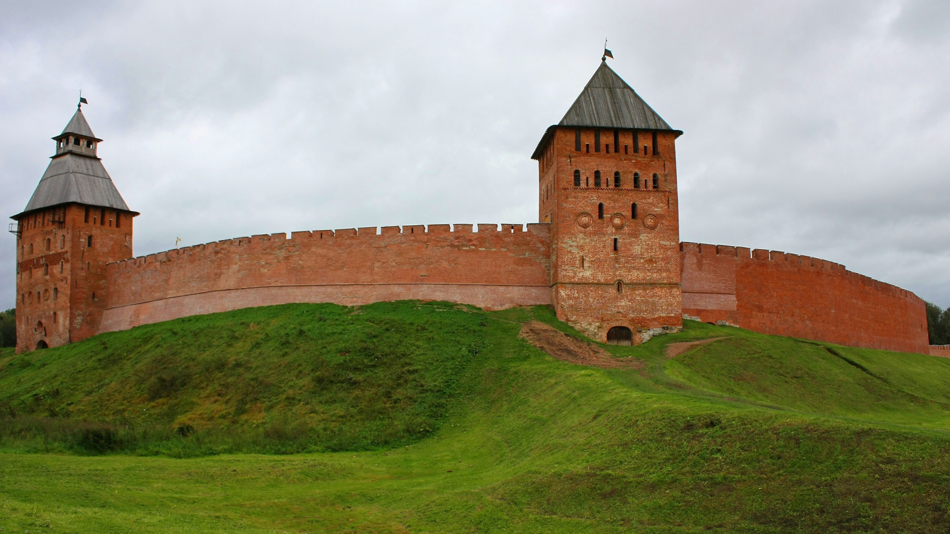 Brown Brick Building on Green Grass Field Under White Clouds During Daytime. Wallpaper in 1920x1080 Resolution