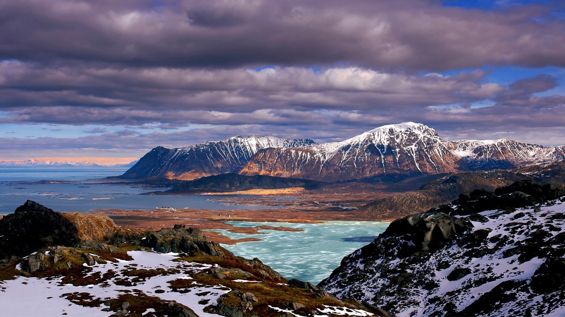 Montagnes Brunes et Blanches Près D'un Plan D'eau Sous un Ciel Nuageux Pendant la Journée. Wallpaper in 1920x1080 Resolution