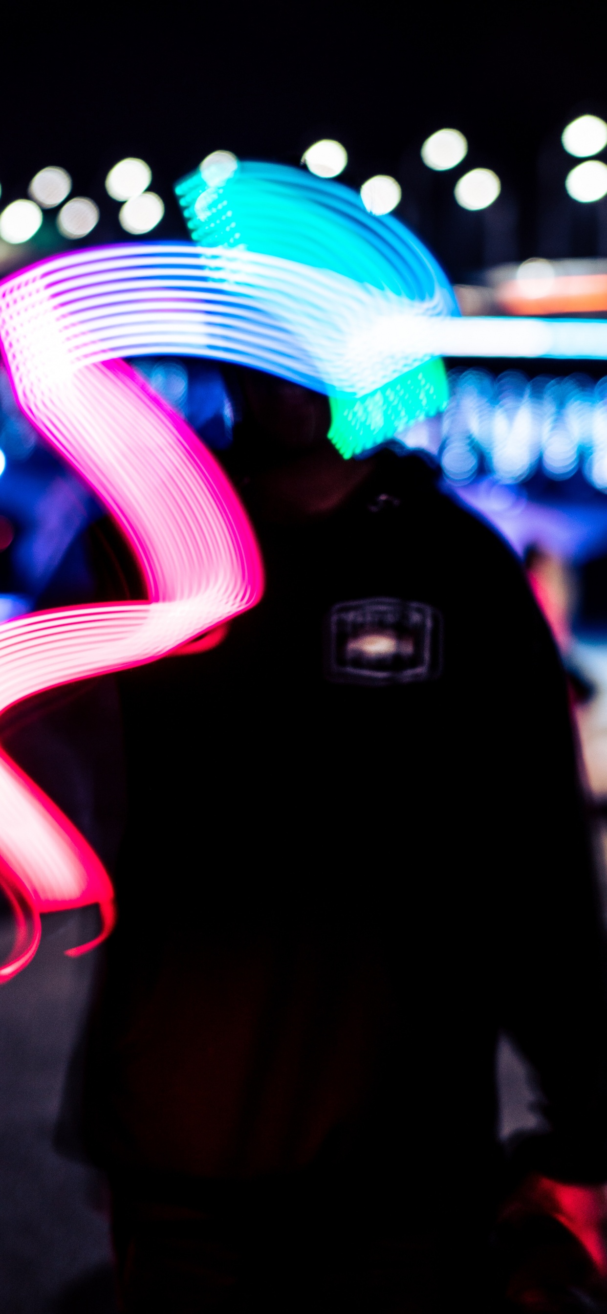 Man in Black Hoodie Standing Near Blue and White Light During Night Time. Wallpaper in 1242x2688 Resolution