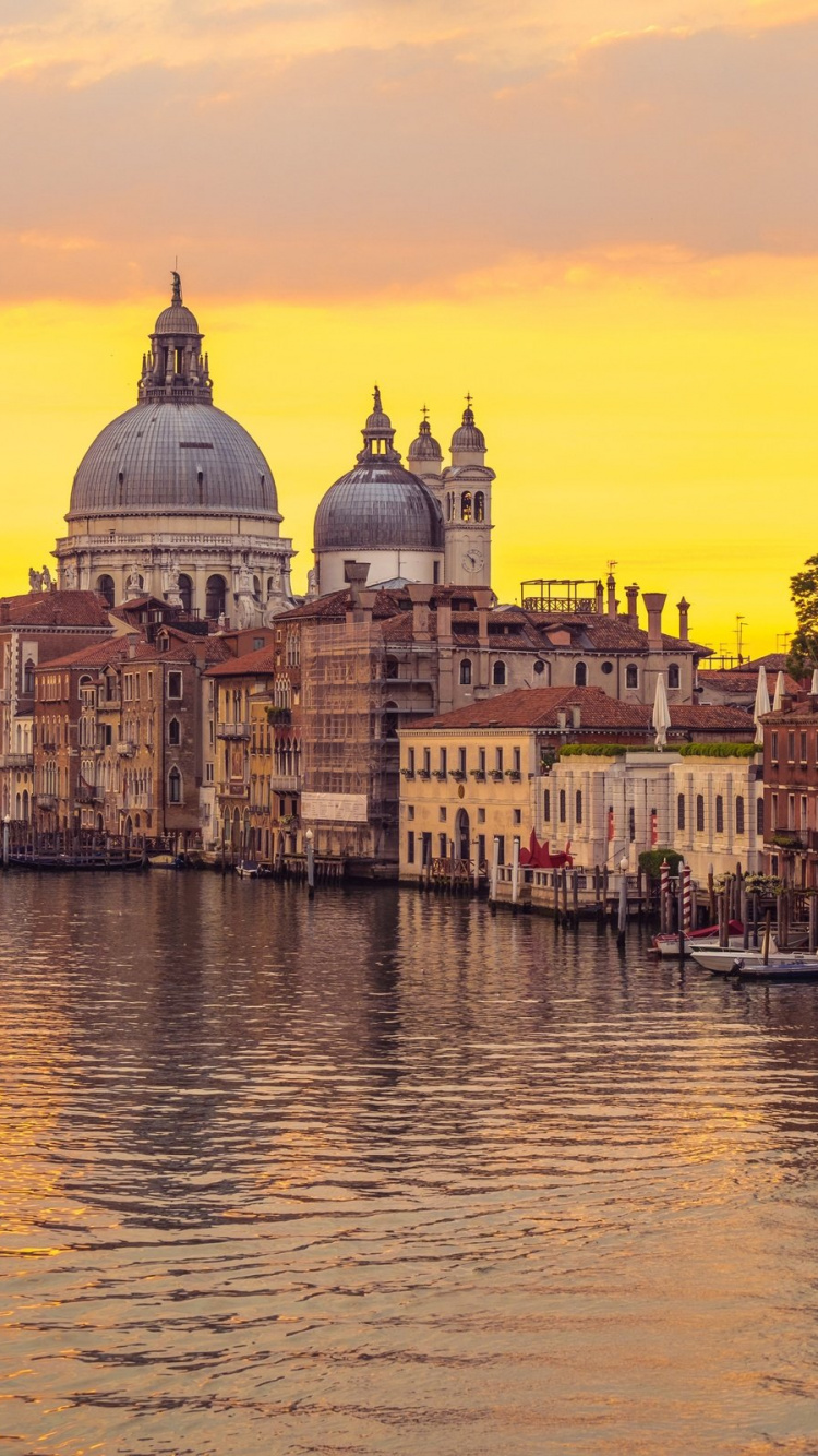 White and Brown Concrete Building Beside Body of Water During Sunset. Wallpaper in 750x1334 Resolution