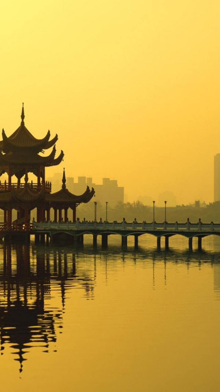 Silhouette of Building Near Body of Water During Sunset. Wallpaper in 720x1280 Resolution