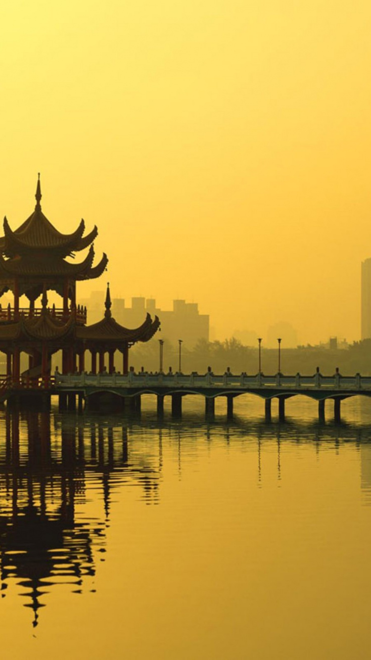 Silhouette of Building Near Body of Water During Sunset. Wallpaper in 750x1334 Resolution