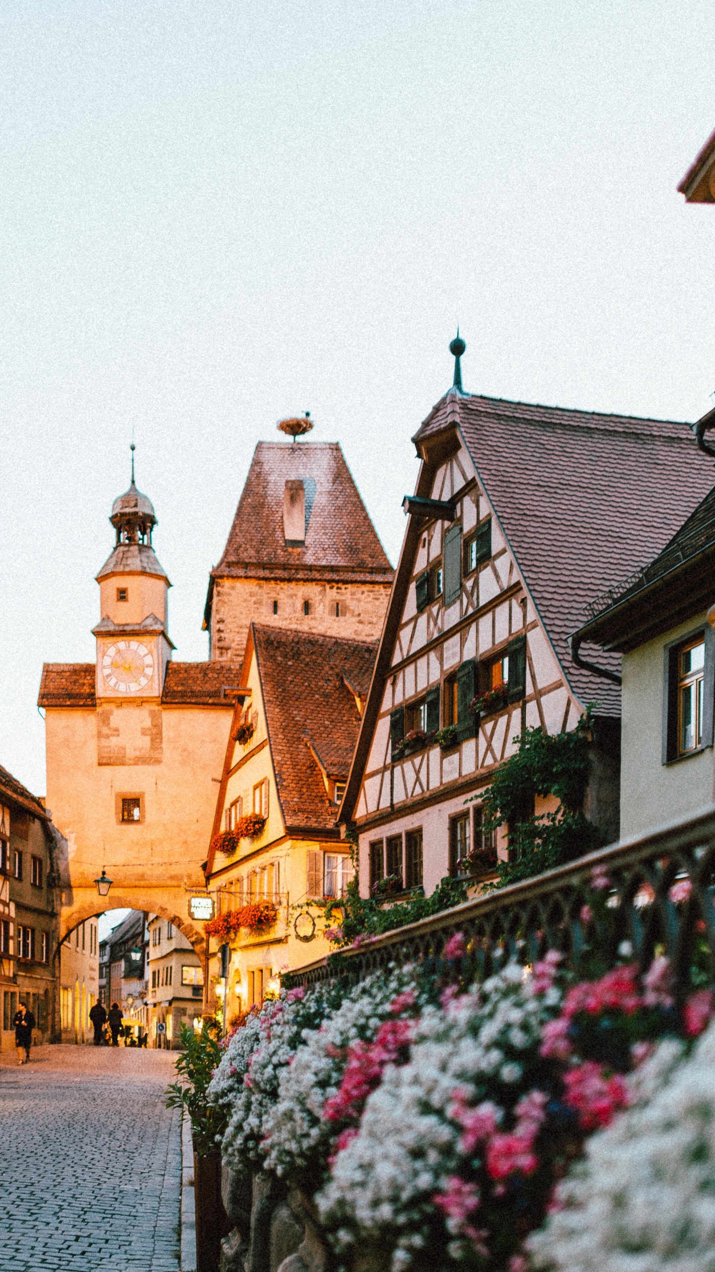 Leute, Die Tagsüber Auf Dem Bürgersteig in Der Nähe Eines Braunen Betongebäudes Gehen. Wallpaper in 1440x2560 Resolution