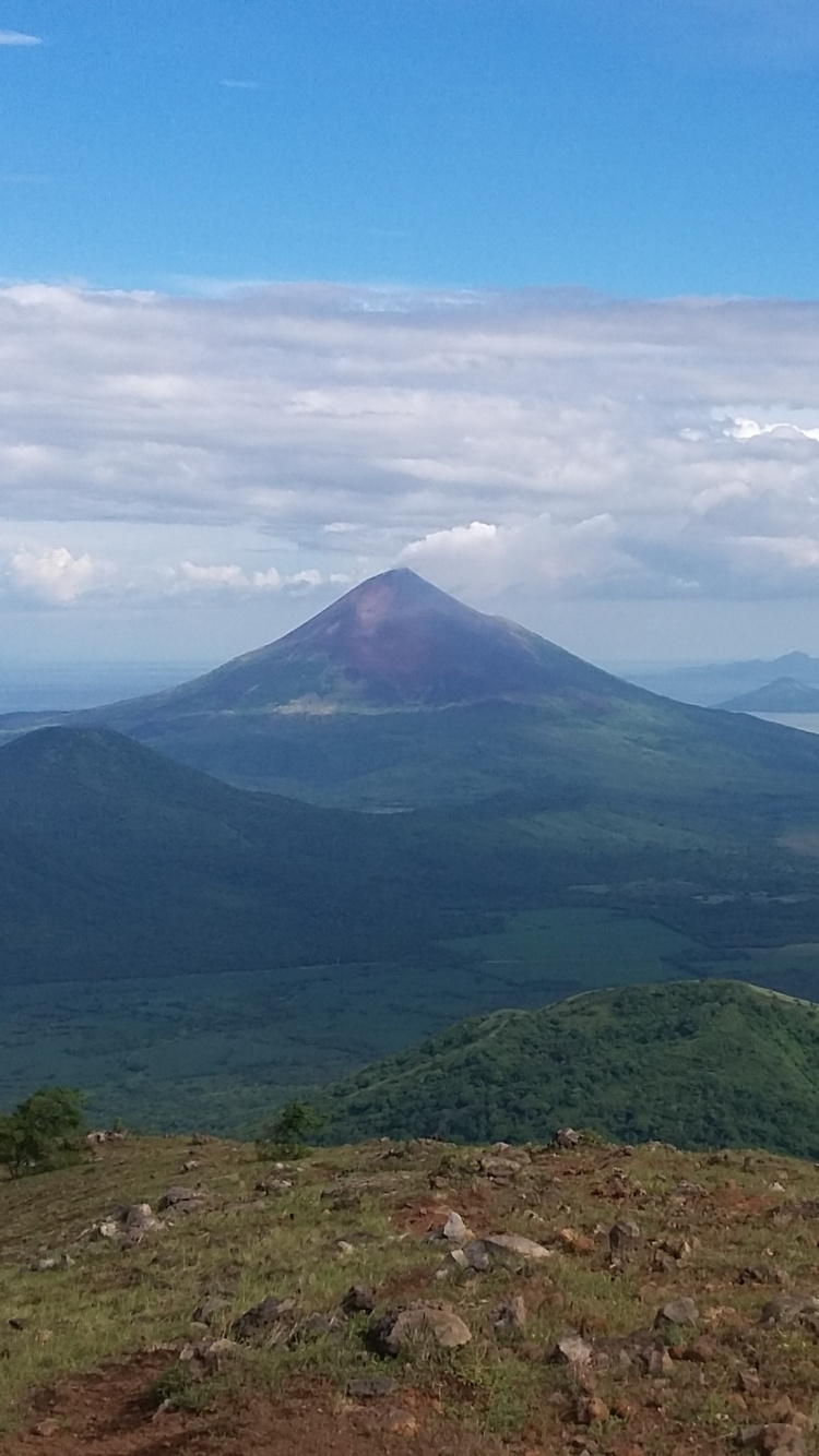 Montaña Verde Bajo un Cielo Azul Durante el Día. Wallpaper in 750x1334 Resolution