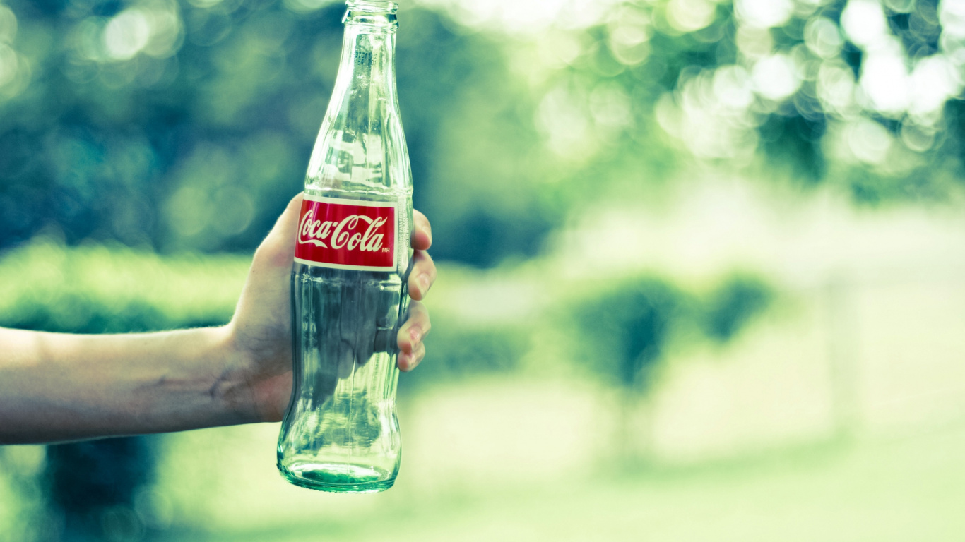Coca-Cola-Glasflasche Auf Der Hand Der Person. Wallpaper in 1366x768 Resolution
