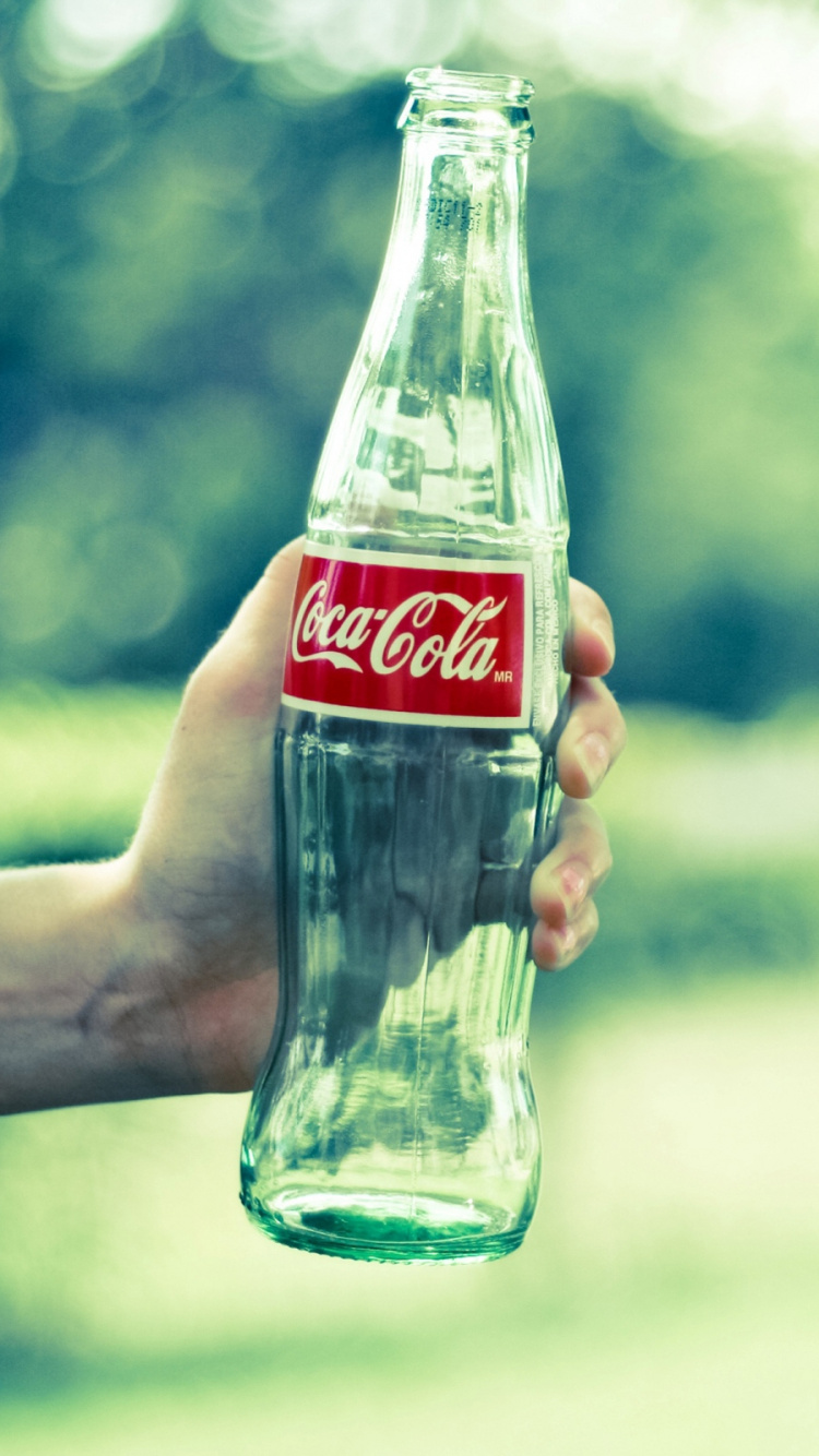 Coca-Cola-Glasflasche Auf Der Hand Der Person. Wallpaper in 750x1334 Resolution