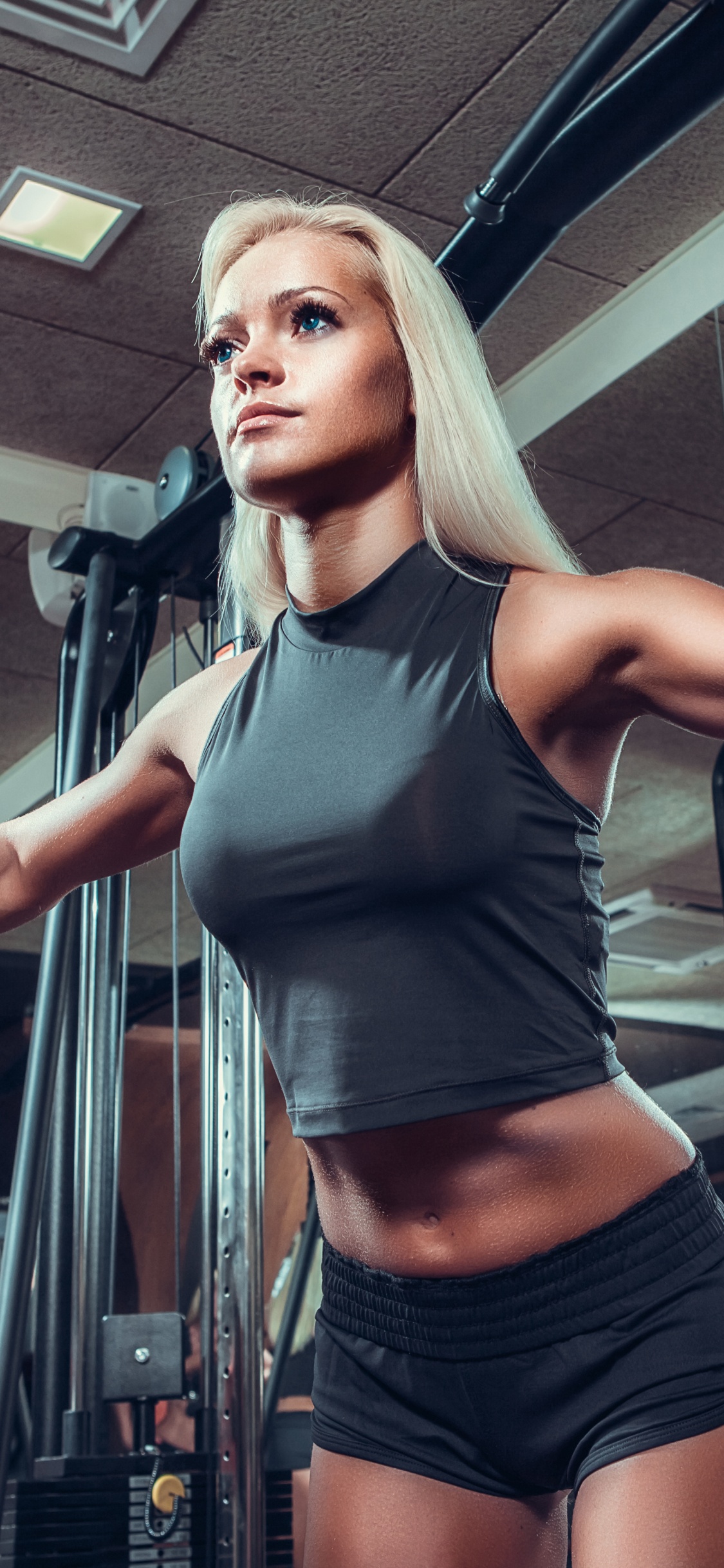 Mujer en Camiseta Sin Mangas Gris y Pantalones Cortos Negros de Pie Sobre la Escalera de Metal Negro. Wallpaper in 1125x2436 Resolution