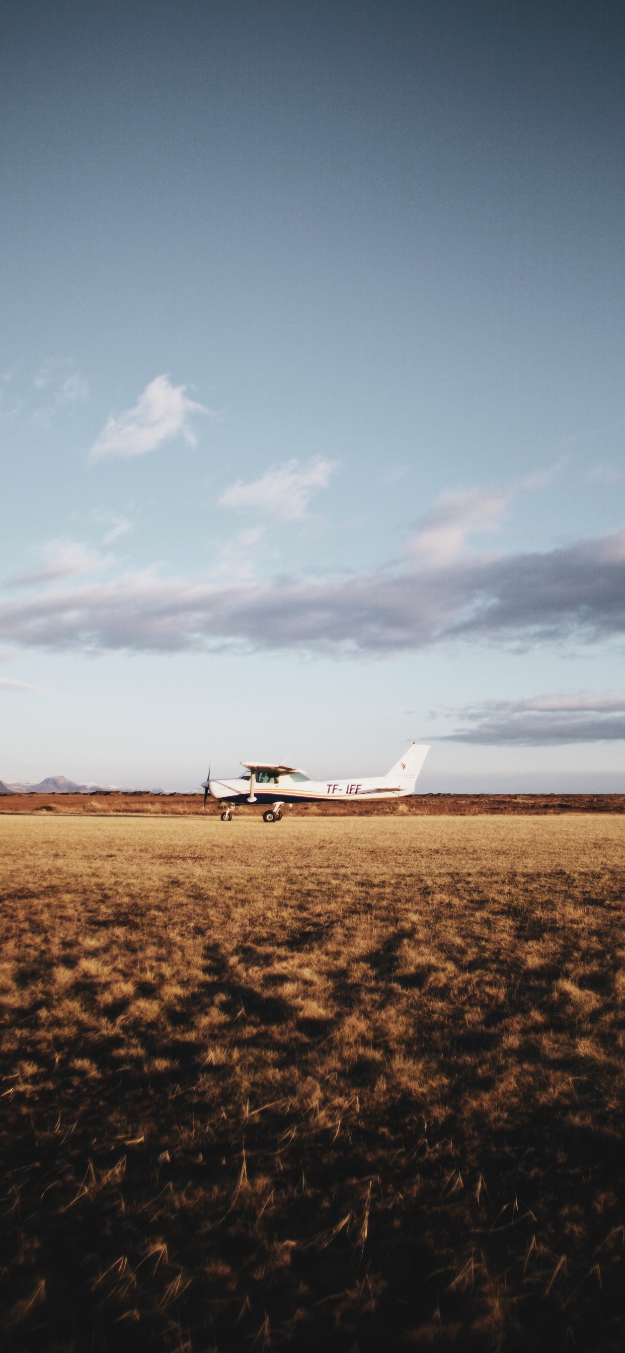 White Airplane on Brown Field Under White Clouds During Daytime. Wallpaper in 1242x2688 Resolution