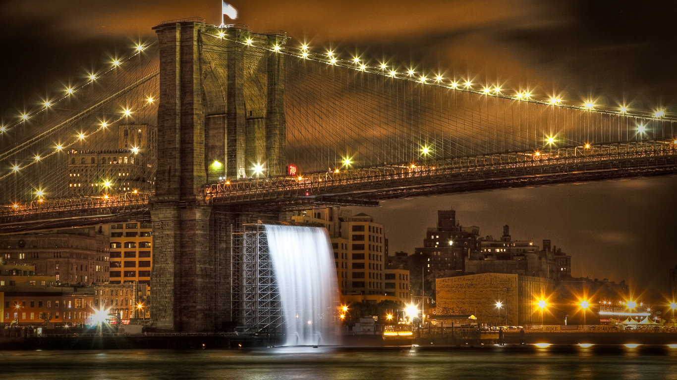 Puente Iluminado Cerca de Los Edificios de la Ciudad Durante la Noche.. Wallpaper in 1366x768 Resolution