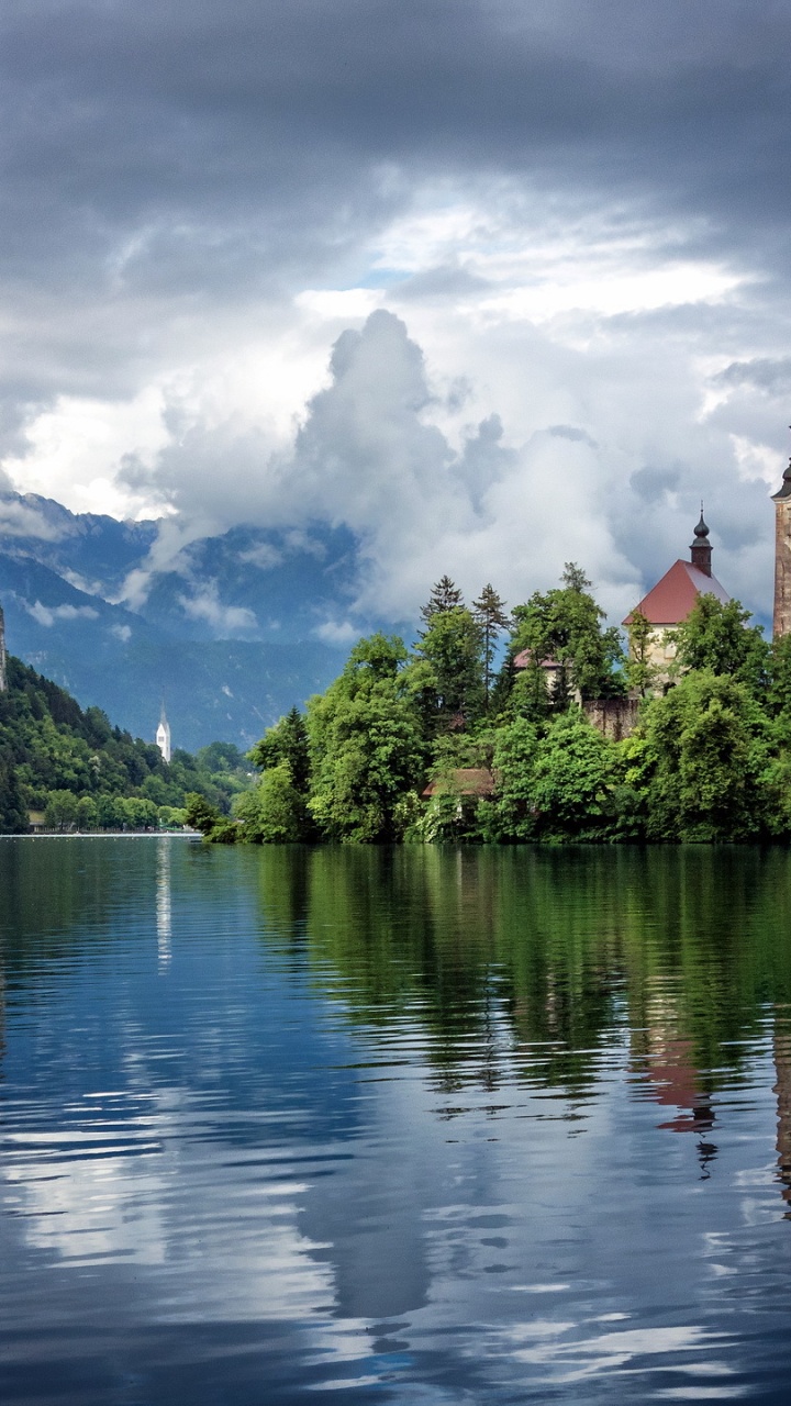 Brown Concrete Building Near Body of Water Under White Clouds and Blue Sky During Daytime. Wallpaper in 720x1280 Resolution