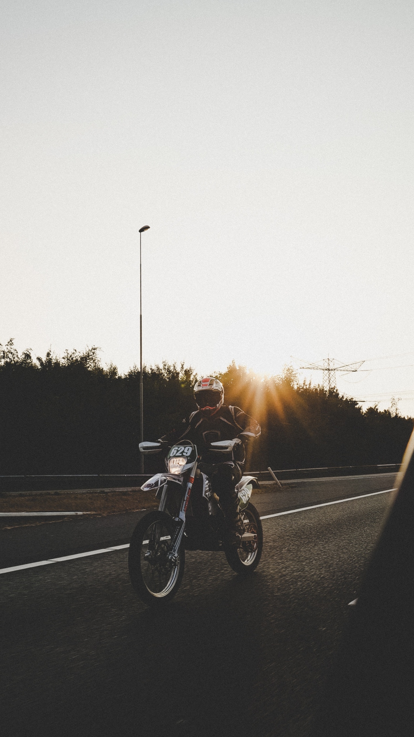 Hombre en Motocicleta en la Carretera Durante la Puesta de Sol. Wallpaper in 1440x2560 Resolution