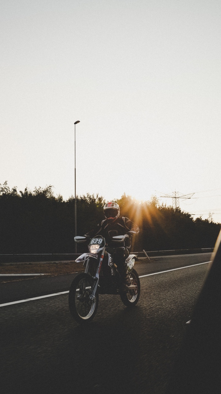 Hombre en Motocicleta en la Carretera Durante la Puesta de Sol. Wallpaper in 720x1280 Resolution