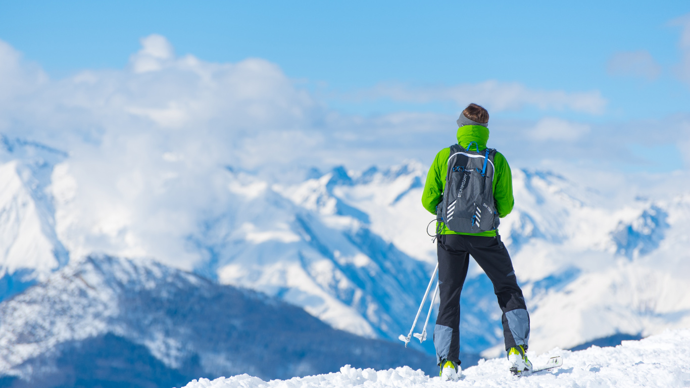 Hombre de Chaqueta Verde y Pantalón Negro de Pie Sobre un Suelo Cubierto de Nieve Durante el Día. Wallpaper in 1366x768 Resolution