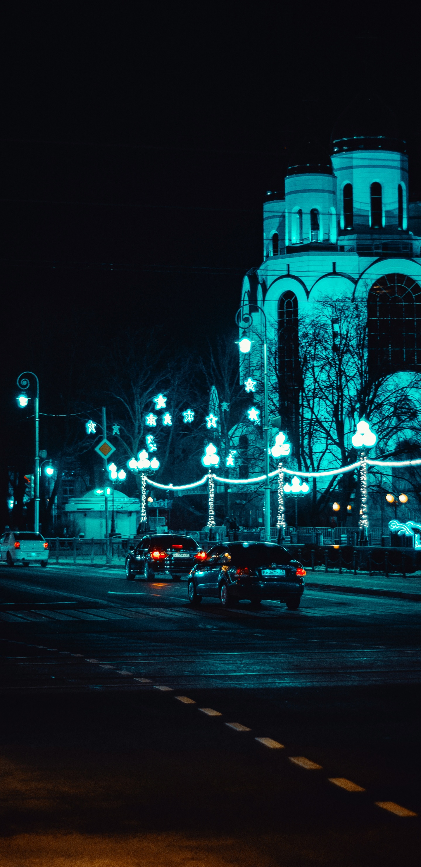 Voitures Sur Route Près D'un Bâtiment Éclairé Pendant la Nuit. Wallpaper in 1440x2960 Resolution