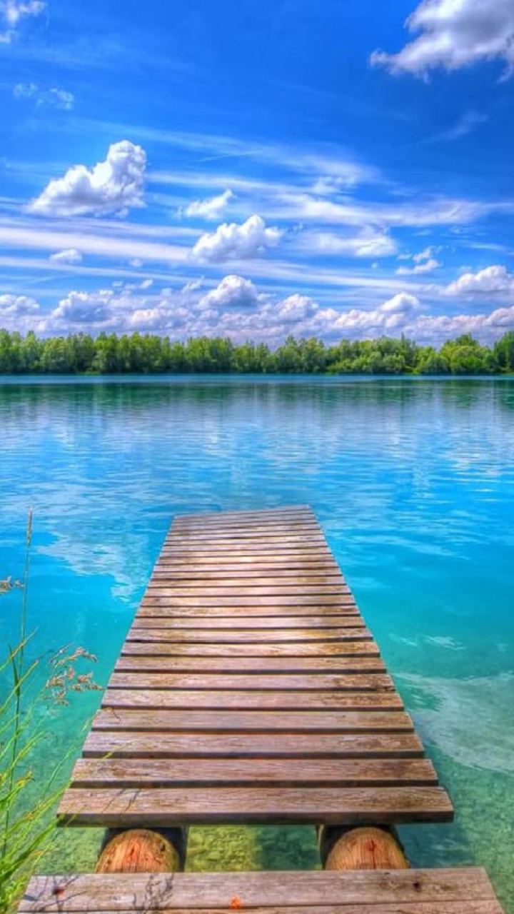 Braunes Holzdock am See Unter Blauem Himmel Und Weißen Wolken Tagsüber. Wallpaper in 720x1280 Resolution